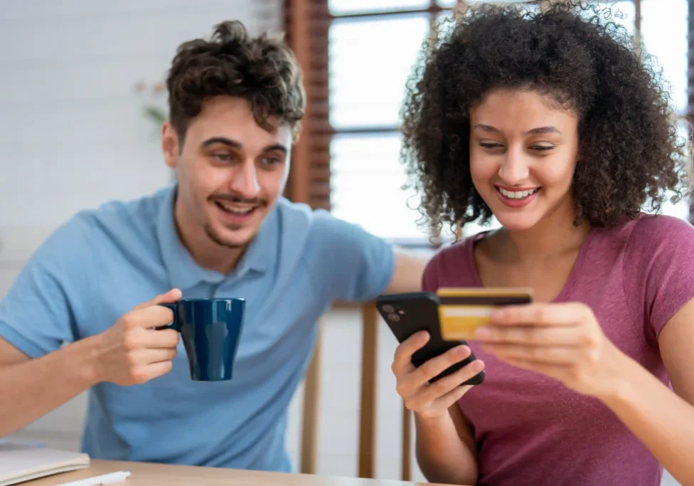 Happy young couple using mobile banking app for financial transactions.